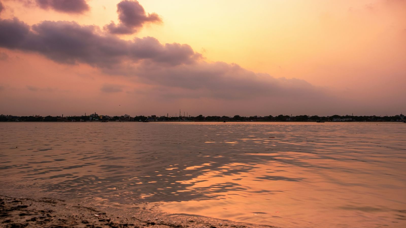 An overview of a river with a pink and yellow sky at in the background.