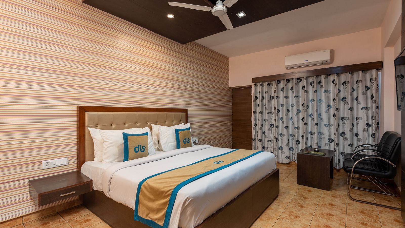 Overview of Deluxe Non view room at DLS Spring Valley resort  Dharamshala featuring a  king bed, table, chairs, AC and a TV