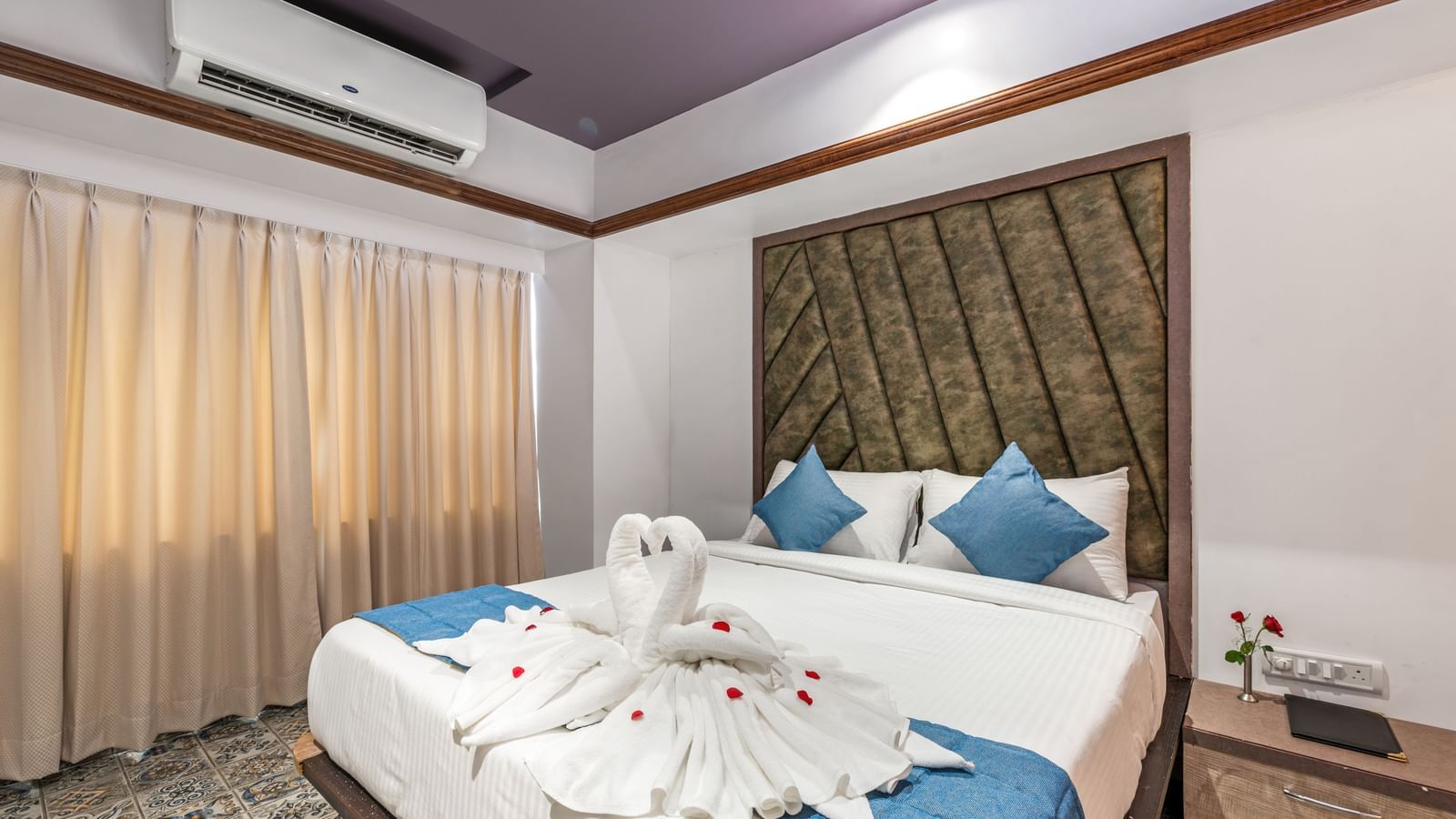 Suite at Emerald Retreat, Tungarli with swan towel decor on the bed, soft ambient lighting, and plush interiors.