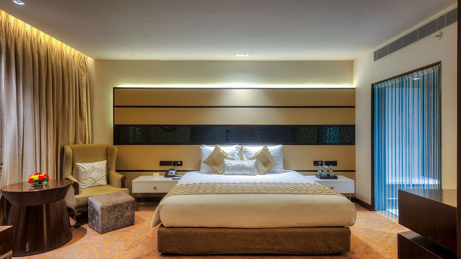 Theme Suite with a king size bed and a sofa chair at Grand Chennai By GRT Hotels.