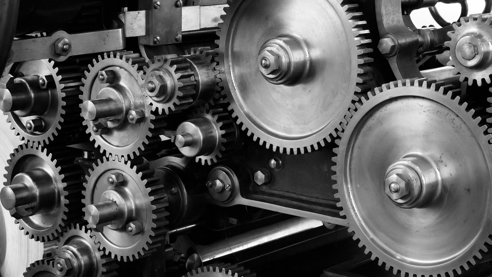 Close-up of interlocking metal gears and cogs, showcasing intricate mechanical details.