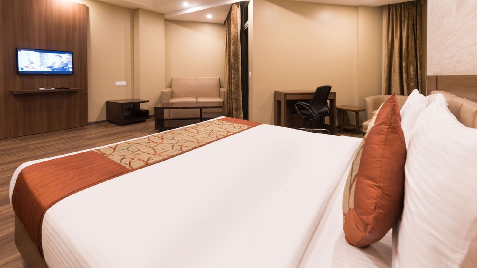 Super Deluxe Rooms with Complimentary Wi-Fi captured with a cosy bed and white linens along with a beige couch - Le ROI Digha Hotel West Bengal3