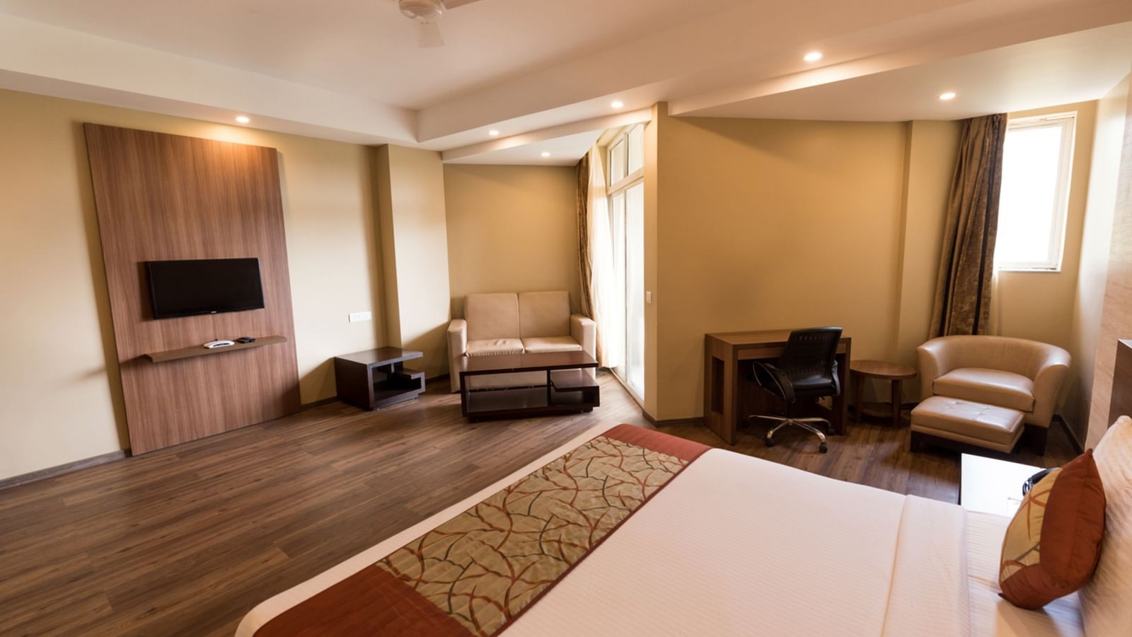 Super Deluxe Rooms with Complimentary Wi-Fi captured with a cosy bed and white linens along with a beige couch - Le ROI Digha Hotel West Bengal8