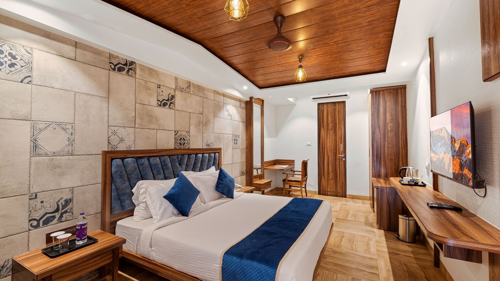 Modern bedroom with a king size bed, wooden ceiling, and stylish lighting at Mayur Retreat.