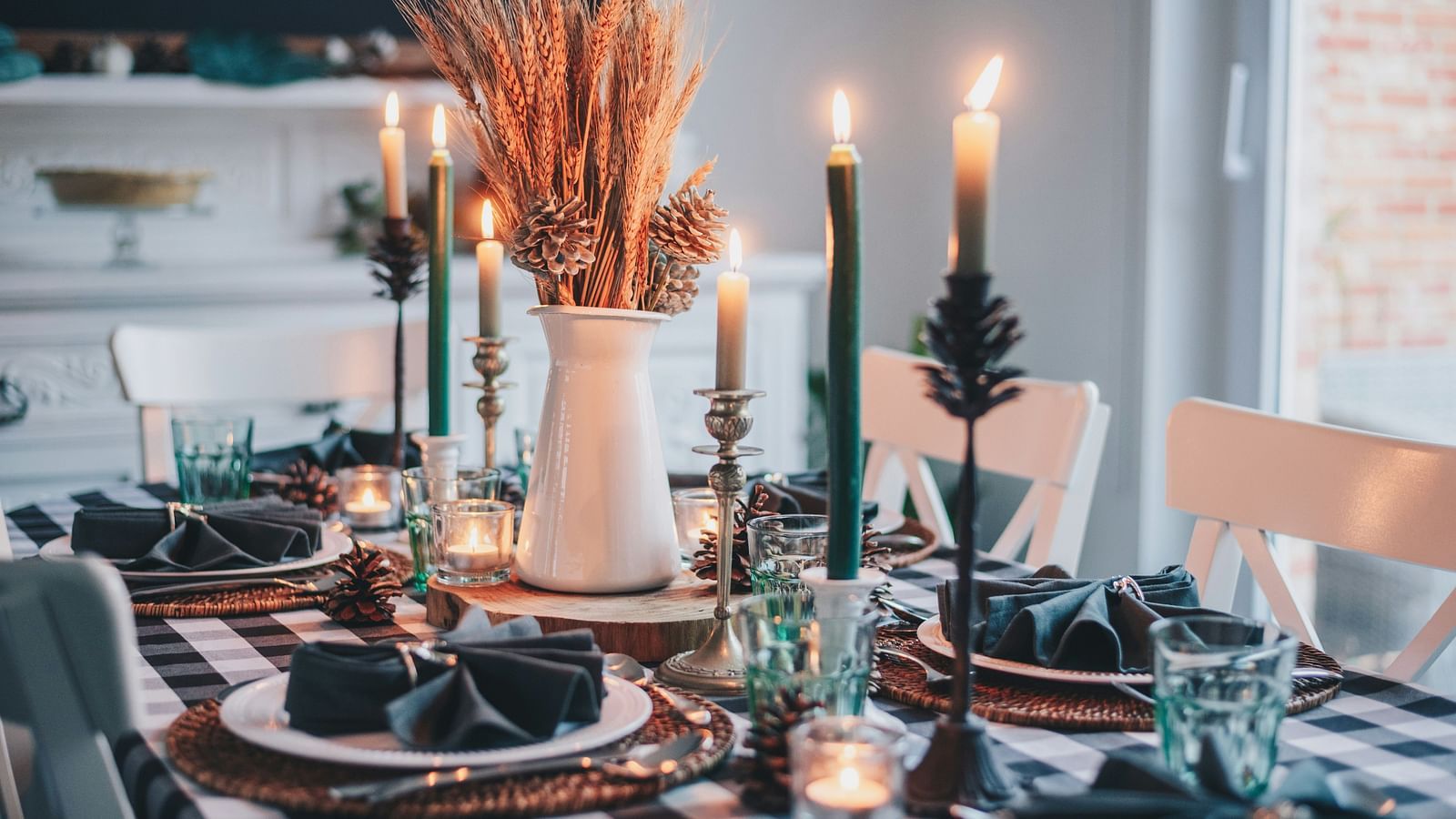 a table set up with candles, other cutleries and a vase kept on the table
