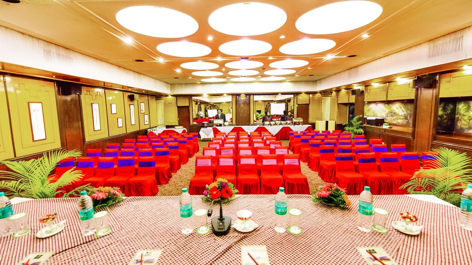 Image of a banquet hall with a table on the pulpit and chairs arranged in front at Swosti Grand, Bhubaneswar