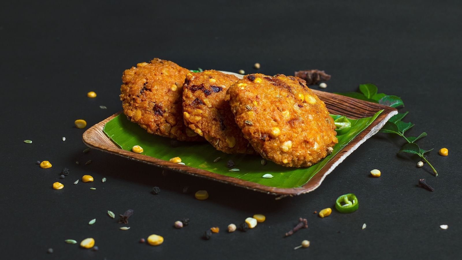 Vadas kept on a green tray on a table.