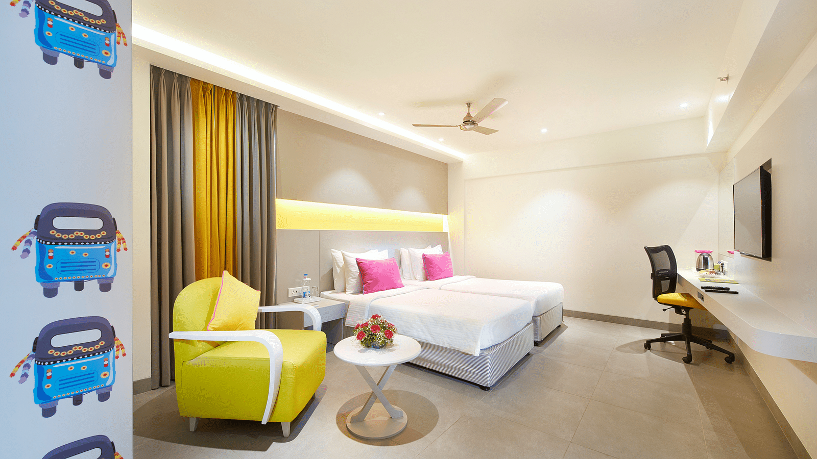 side view of a bedroom with a working table and a chair at  Zibe Salem by GRT Hotels