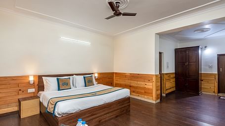 Image of well furnished room featuring a king size bed and a large open space with wooden flooring | DLS Anupam Resort, Dharamshala