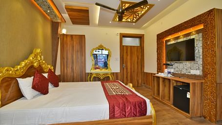 Super Deluxe Room at DLS Dalhousie Valley Resort with a  king size bed, a TV and ambient lighting 