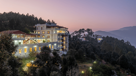 A panoramic view of the DLS Tehri Club Resort at sunset, nestled amidst the scenic hills.