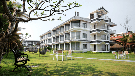 A similar shot of Hotel Sonar Bangla with the lawn and pathway, highlighting the clean, modern architecture.