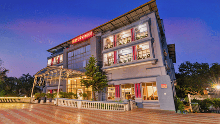 Side-angle view of the exterior view of Mayur Retreat and Spa under a dark blue sky with a well-lit building.