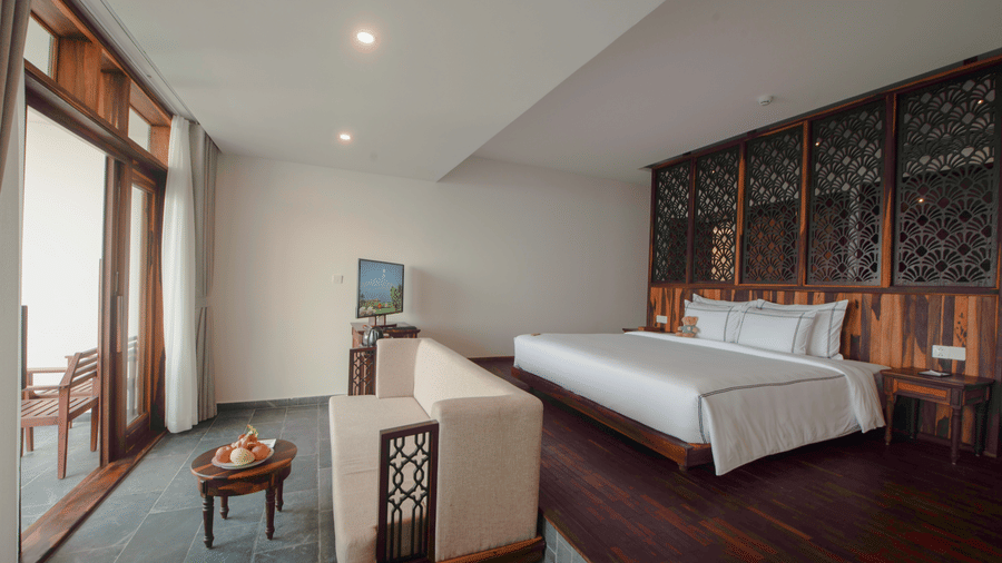 Executive Ocean Suite featuring a bed and a sofa facing the doorway to the sit-out at Alibu Resort in Nha Trang