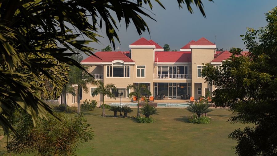 Facade view of BluSalzz Resort with garden and trees in the front.