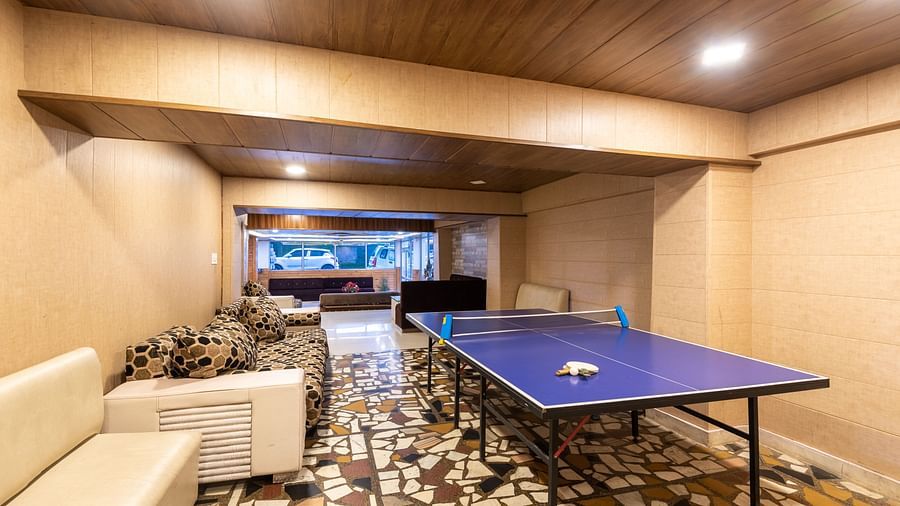 Image of a table tennis zone kept in the lobby with a white couch in the side | DLS Anupam Resort, Dharamshala