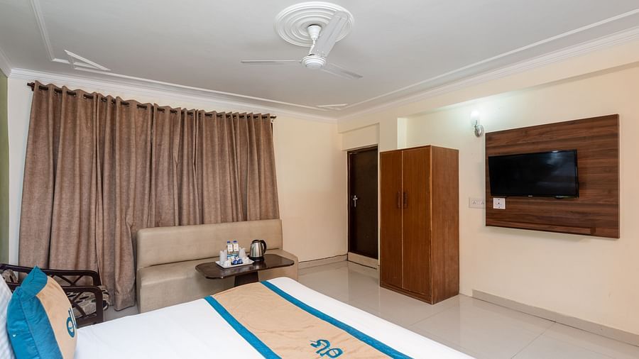 close up image of a bed in a room that is also featuring a television and a wardrobe | DLS Anupam Resort, Dharamshala