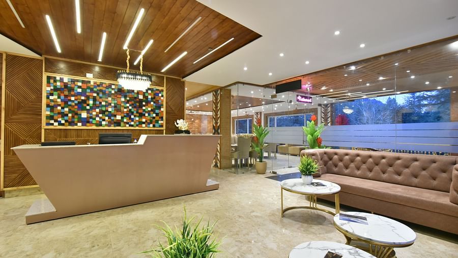 A reception desk in front of sofa seating in the lobby at DLS Ark Holiday Inn, Banikhet.