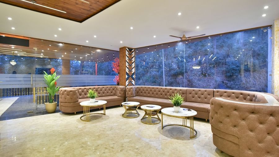 A large sofa in front of coffee tables in the lobby at DLS Ark Holiday Inn, Banikhet.