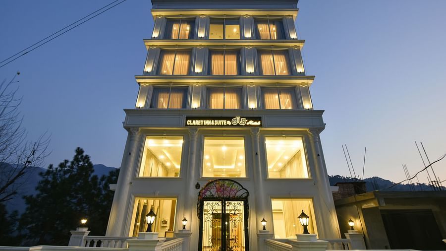 A striking image of a contemporary hotel building with a unique, multi-level design, illuminated at night against the backdrop of mountains.