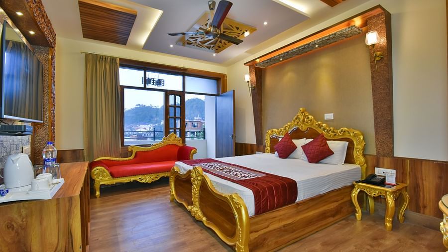 A Luxury Room at DLS Dalhousie Valley Resort with a premium bed, a sofa and balcony.
