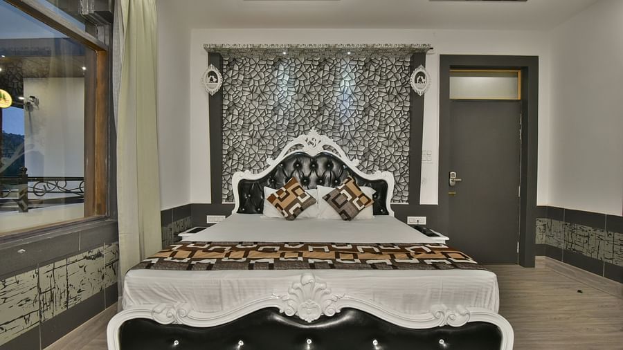 A Luxury Room at DLS Dalhousie  Valley Resort with a premium bed and balcony.