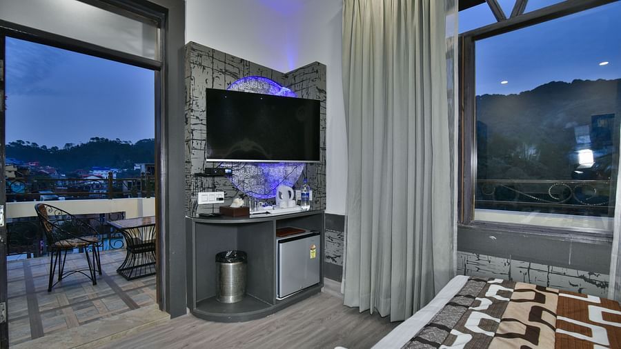 Super Deluxe room at DLS Dalhousie Valley Resort featuring a balcony, TV and other amenities. 