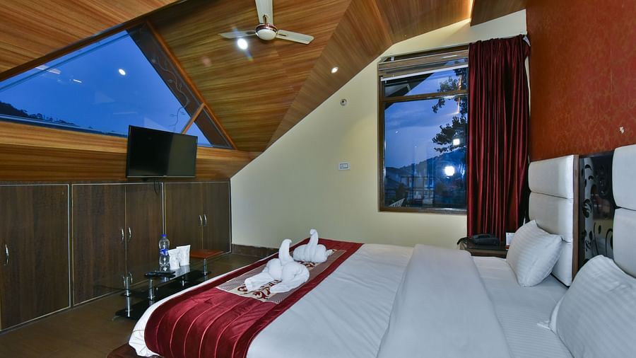 Family Suite at DLS Dalhousie Valley Resort with a king size bed, a table, chairs and a window. 