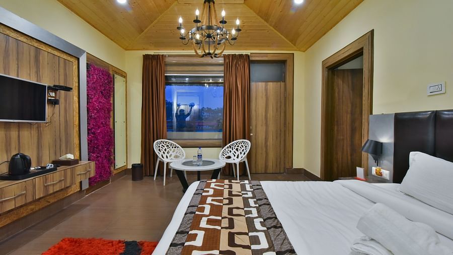 Family Suite at DLS Dalhousie Valley Resort with a  king size bed, a table, chairs and a balcony 
