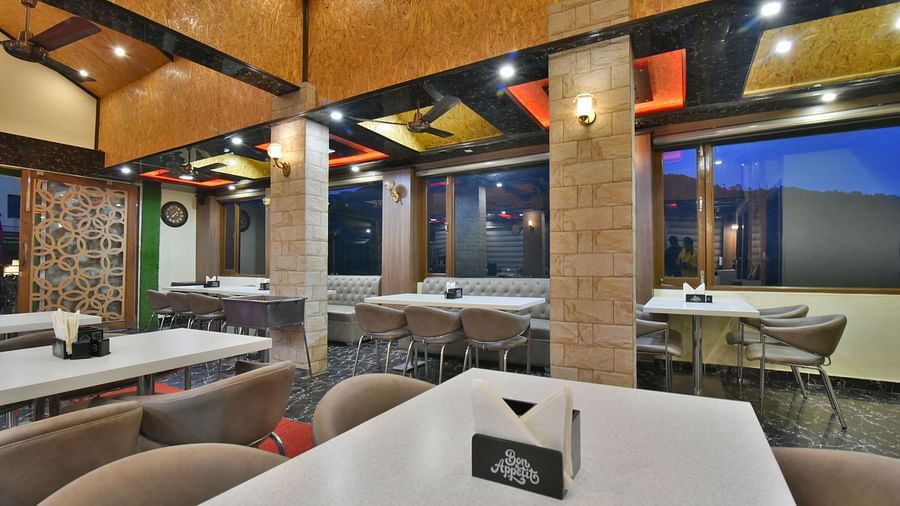 Restaurant at DLS Dalhousie Valley Resort with chairs, tables and serene views