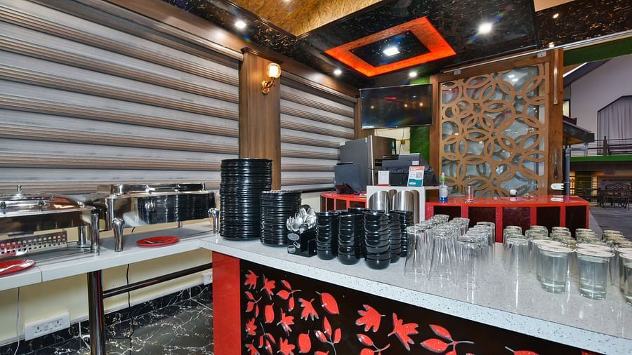 Buffet counter at DLS Dalhousie Valley Resort with various dishes and cutlery kept on the table.