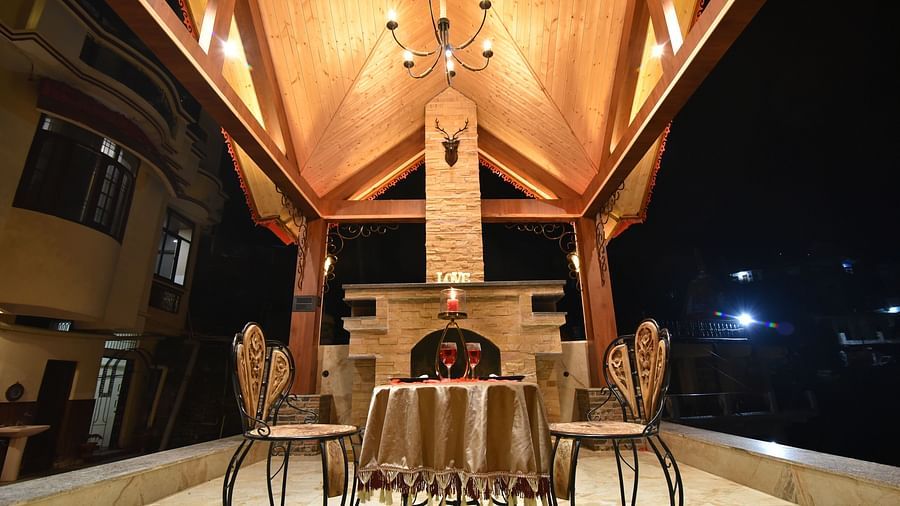 A Gazebo at DLS Dalhousie Valley Resort with beautiful chairs, table and a chandelier 