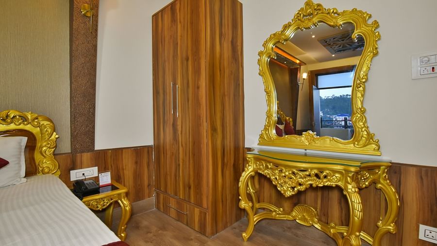 A Luxury Room at DLS Dalhousie  Valley Resort with a premium bed, wardrobe and mirror.
