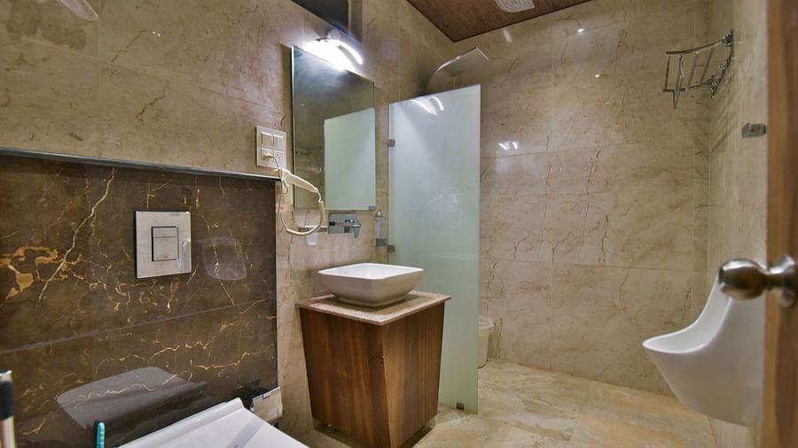 Bathroom of Deluxe Room at DLS Dalhousie Valley Resort with a sink mirror and a toilet.
