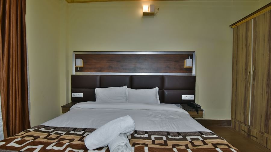 Family Suite at DLS Dalhousie Valley Resort with a king size bed, towels and ambient lighting. 