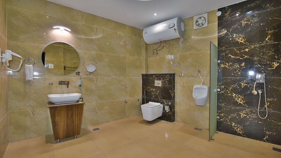 Bathroom of Family Suite at DLS Dalhousie Valley Resort with a sink mirror and a toilet.