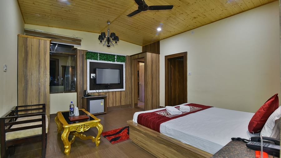 Family Suite at DLS Dalhousie Valley Resort with a king size bed, a table, sofa and a TV 