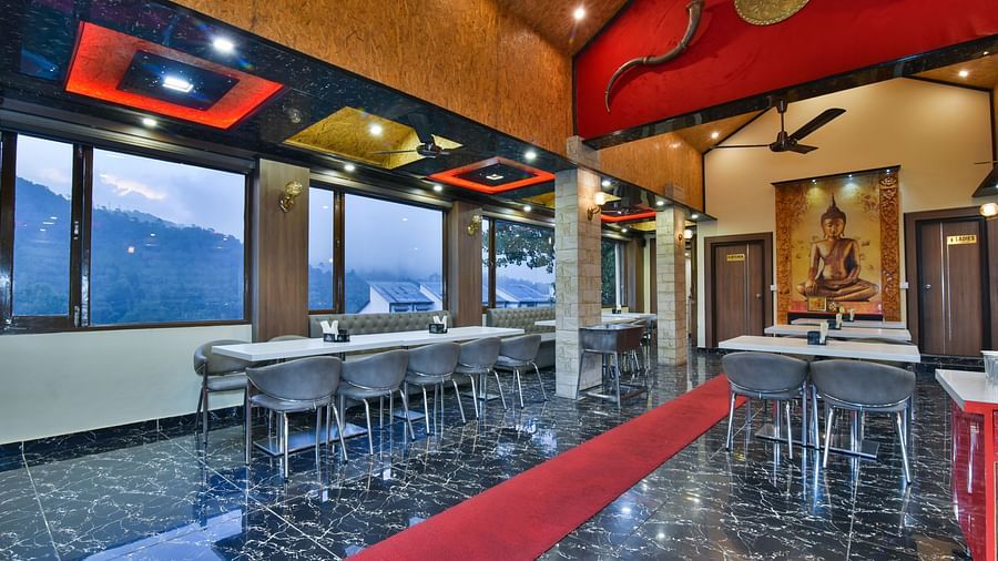Restaurant at DLS Dalhousie Valley Resort with chairs, tables and serene views