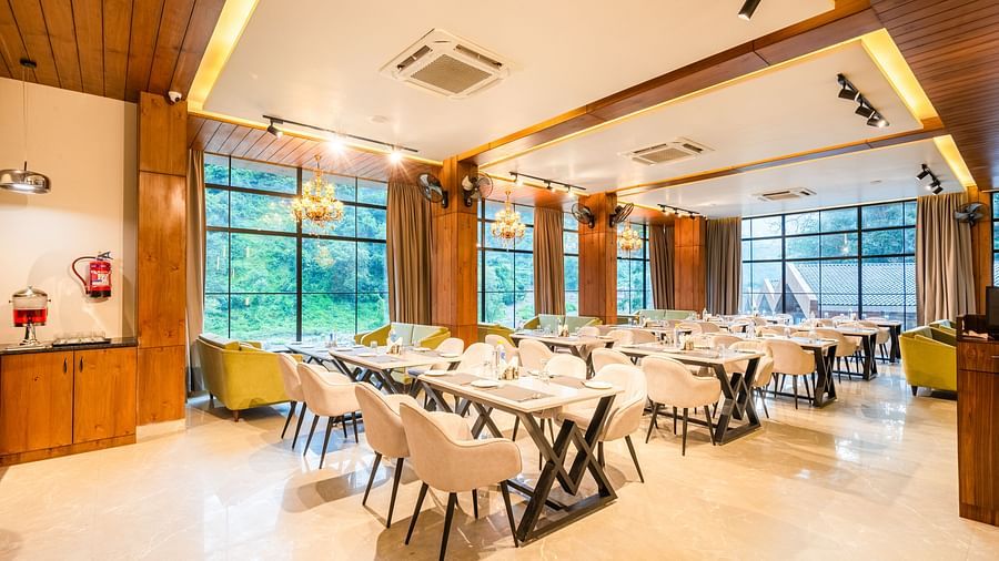Restaurant at DLS Divine River Resort and Spa  with seating arrangement, large window and ambient lighting. 