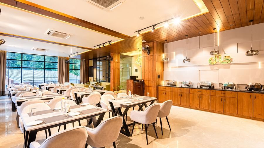 Restaurant at DLS Divine River Resort and Spa  with seating arrangement, large window and ambient lighting. 