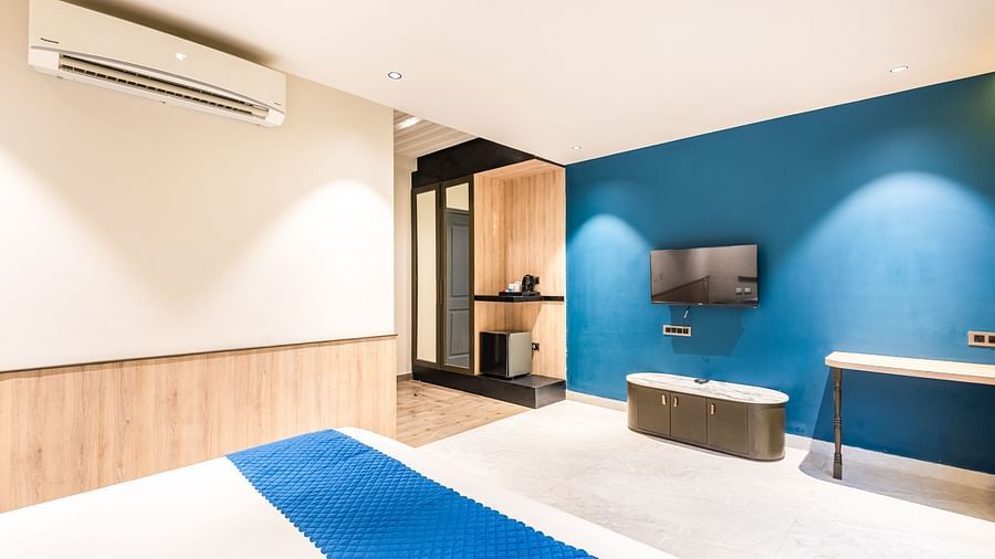 Deluxe Room at DLS Divine River Resort and  Spa featuring a  king bed , side table, TV,  warm lighting and other amenities.