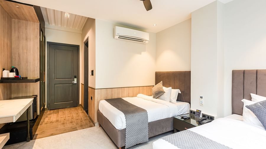 Deluxe Room at DLS Divine River Resort and  Spa featuring a two king bed , side table, warm lighting and other amenities.