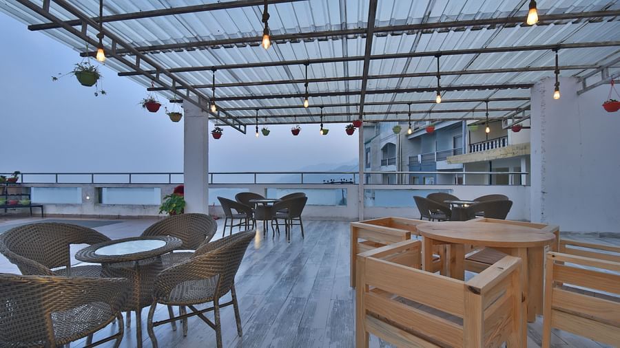 A view of the cafe with comfortable seating area at the rooftop at DLS Highland Resort and Spa, Mussoorie.