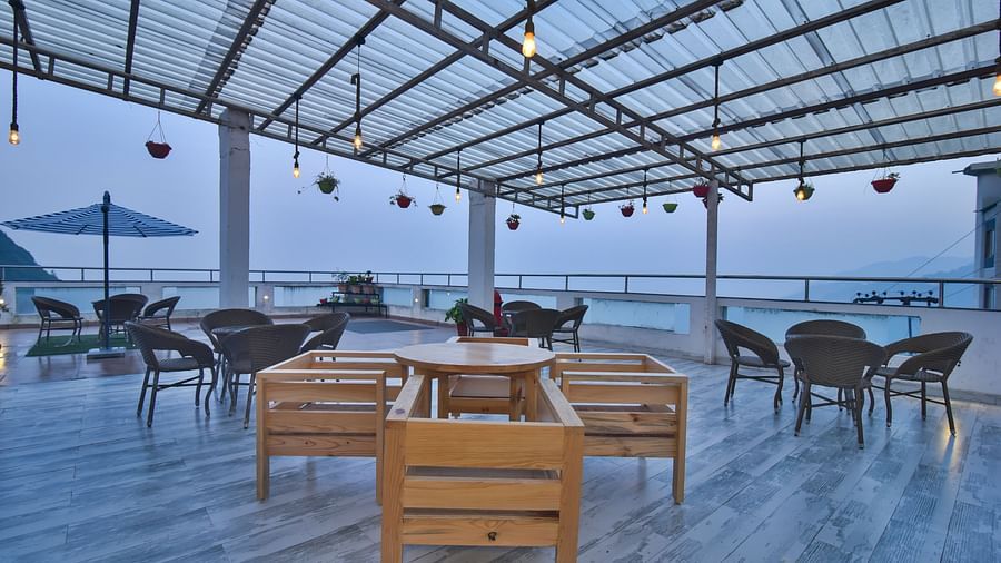 A view of the cafe with comfortable seating area at the rooftop at DLS Highland Resort and Spa, Mussoorie.