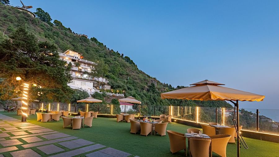 Comfortable seating in the lawn surrounded by hills at dusk at DLS Highland Resort and Spa, Mussoorie.