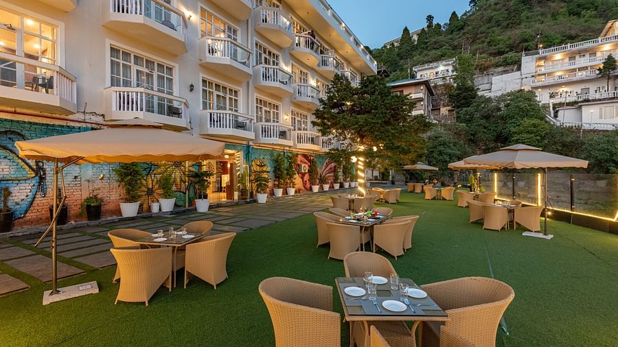 Comfortable seating in the lawn surrounded by hills at dusk at DLS Highland Resort and Spa, Mussoorie.