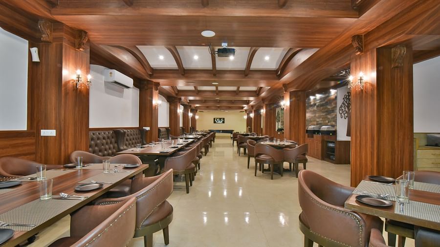 Dining seating with comfortable chairs around table at Ruttba at DLS Highland Resort and Spa, Mussoorie.