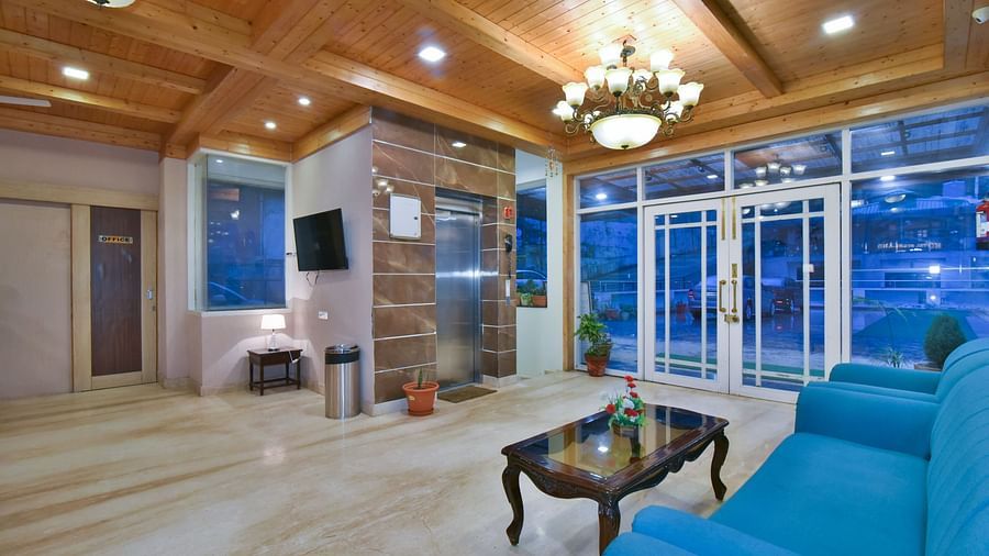 Reception area with a comfortable sofa in front of the lift at DLS Highland Resort and Spa, Mussoorie.