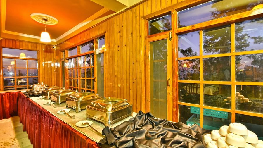 Buffet area with plates, bowls, and cutlery at DLS Hillcrest Resort, Shimla.