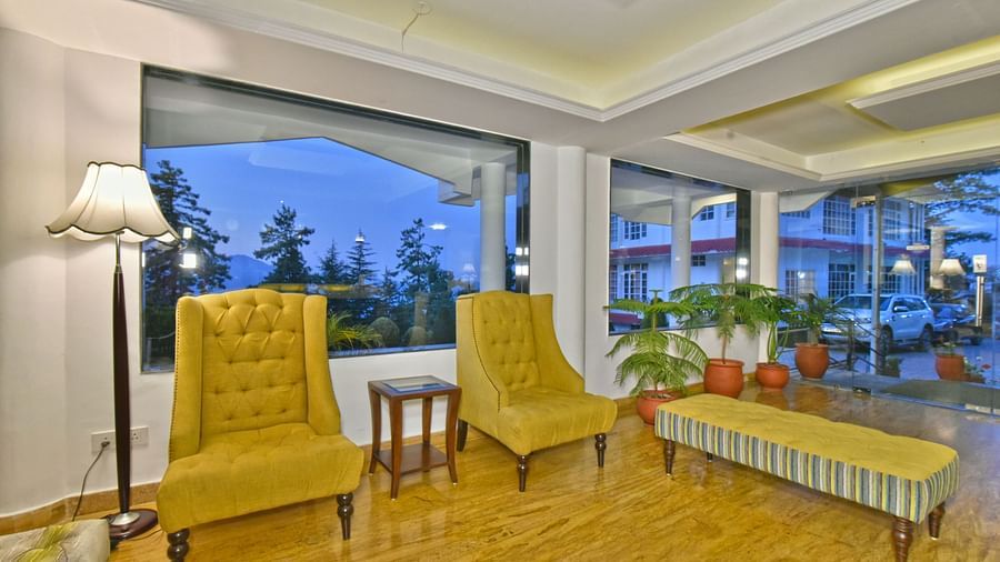 Lobby space with a two cushioned chairs and a small table placed between them at DLS Hillcrest Resort, Shimla